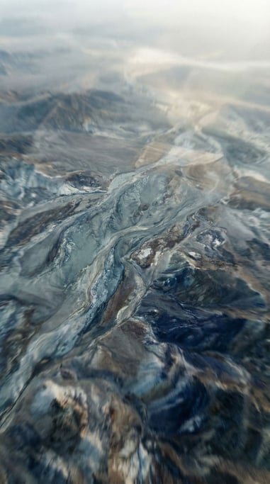 Thick oil paint being mixed on a palette, swirling veins of color caught mid-motion (uud8utd)