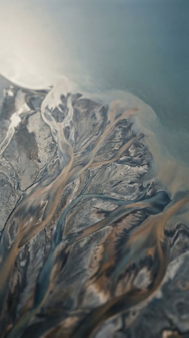 Satellite view of river deltas branching into the sea, fractal patterns in blue and brown (euwhs2l8)