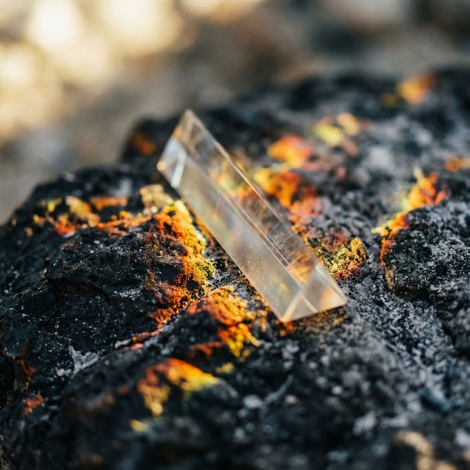 Light refracting through a crystal prism, rainbow caustics scattered across a dark surface (u9ihrkeb)