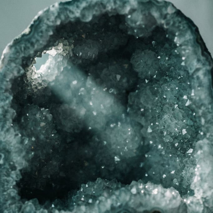 The inside of a geode, druzy crystal coating catching light from a single source, cave of light