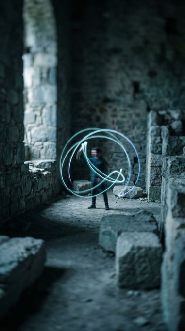 Light painting with a long exposure, human figure drawing neon trails in a dark space (ep9li5lt)