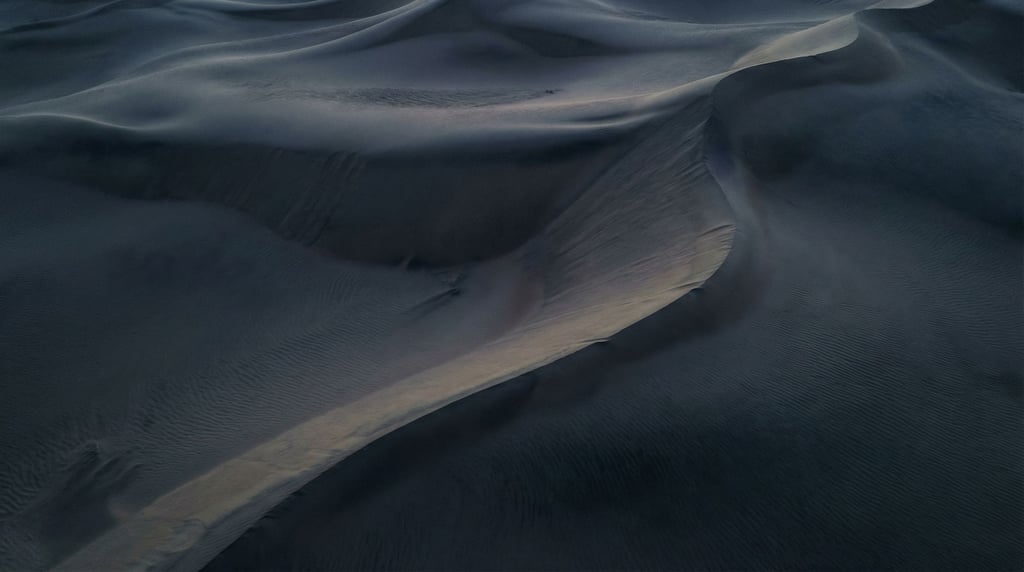 Sand dunes seen from above, abstract curves and soft shadows in cool morning light (rfm1yyay)