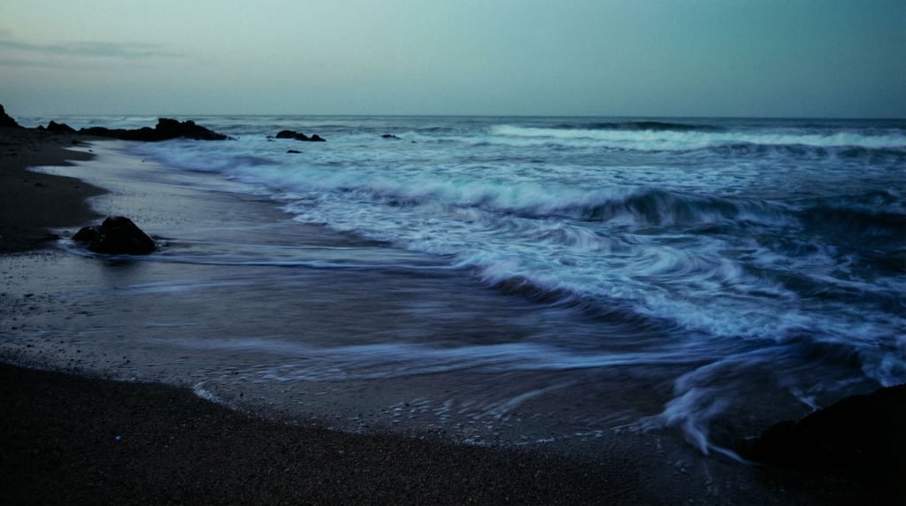 Bioluminescent plankton in surf at night, glowing blue waves breaking on dark sand (owmfnzap)