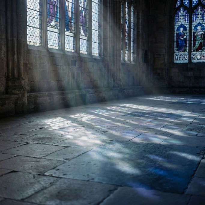 Sunlight through cathedral stained glass, colored light patterns on a stone floor (cbbqrip)