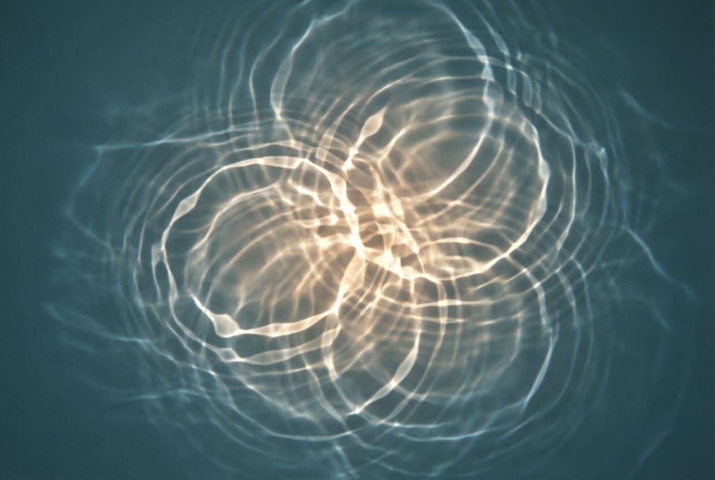 Light caustics ripple across a dark teal surface