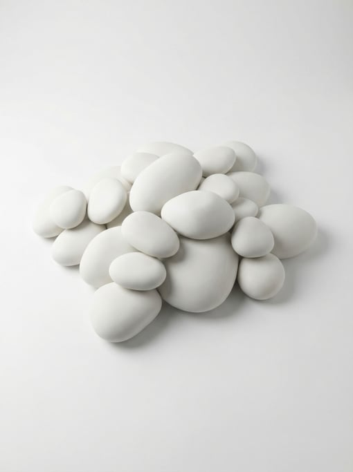 Glossy ceramic pebble shapes in all-white cluster together like a cloud of smooth river stones
