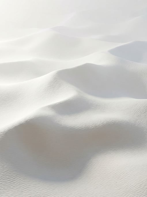 Undulating sand dunes rendered in all-white stretch across the frame — soft directional light from t