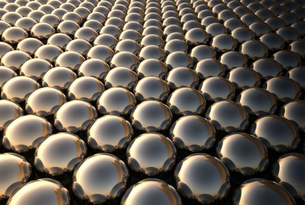 A field of tiny metallic hemispheres protruding from a flat surface like the inside of a sound-dampening panel