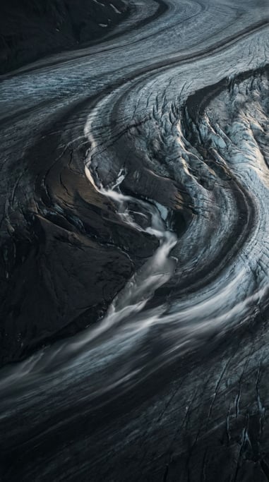 Aerial view of a glacier, crevasses and blue-white ice fields, abstract patterns from above