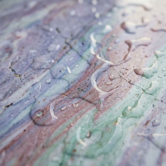 Wet marble surface with water pooling in natural veins and cracks, overhead view (6fccwh7w)