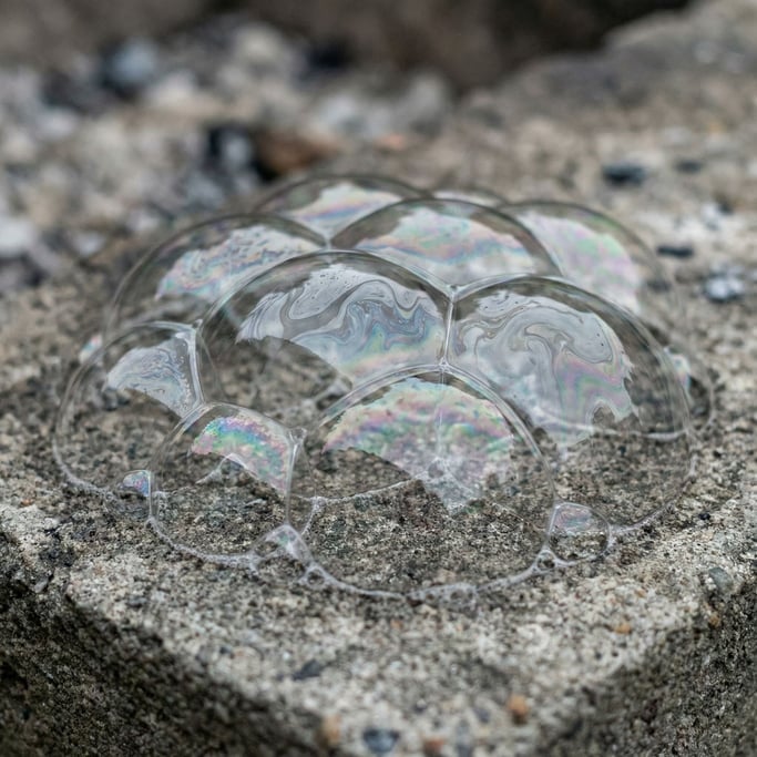 Macro shot of soap bubbles, iridescent surface tension and interference patterns (h935xmql)