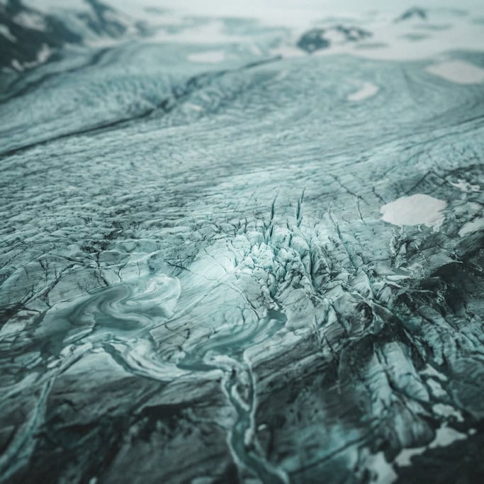 Aerial view of a glacier, crevasses and blue-white ice fields, abstract patterns from above (z0hssvro)