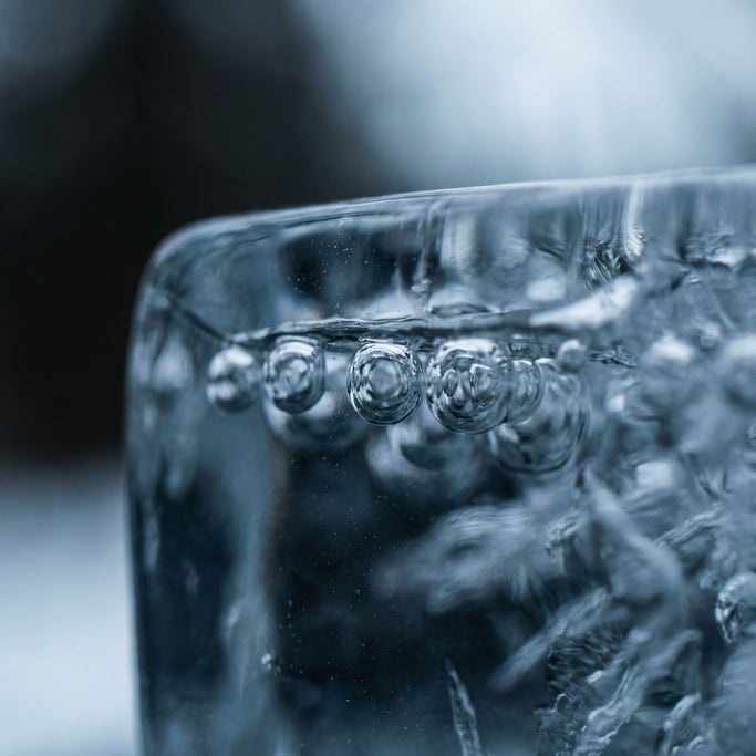 Frozen air bubbles trapped in clear blue ice, macro shot, cool crystalline tones (bnlsk30e)