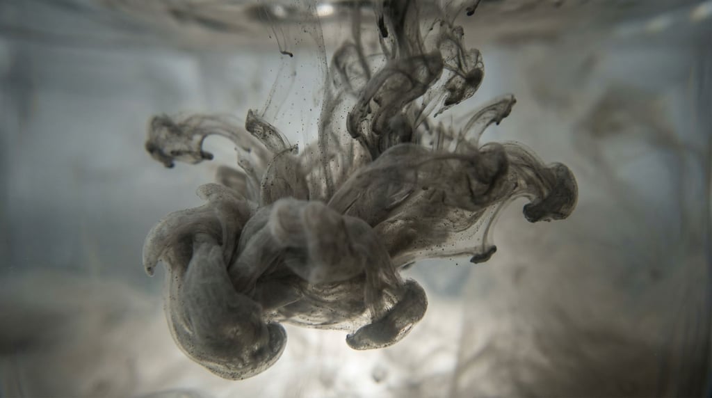 Ink dropped into water, tendrils expanding in slow motion, backlit from below (9gapinix)