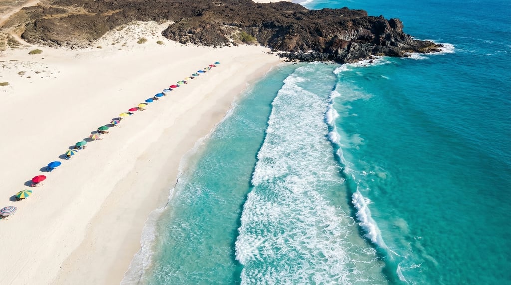 Aerial view of a long white sand beach with turquoise waves breaking in parallel lines