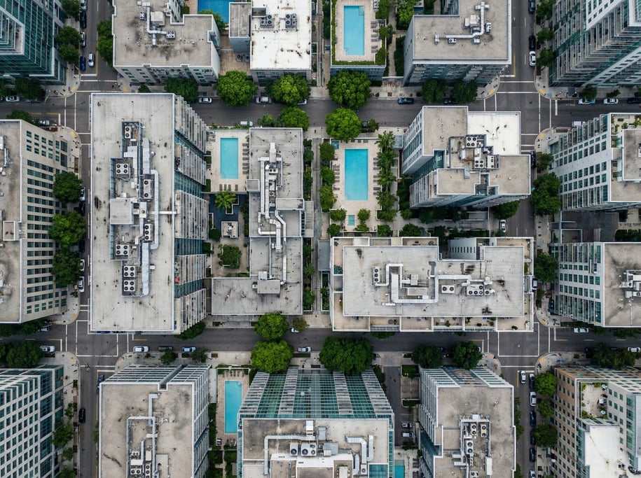 Aerial view of a modern city block from directly above showing flat rooftops with HVAC equipment