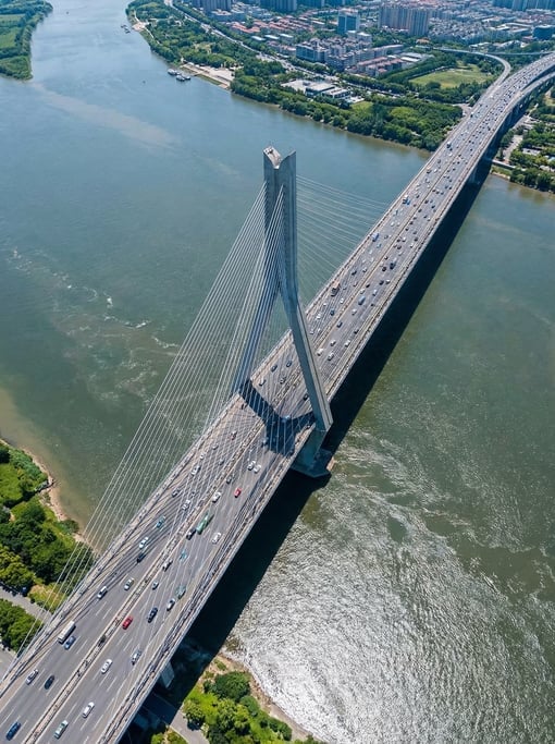 Top-down shot of a modern bridge spanning a wide river