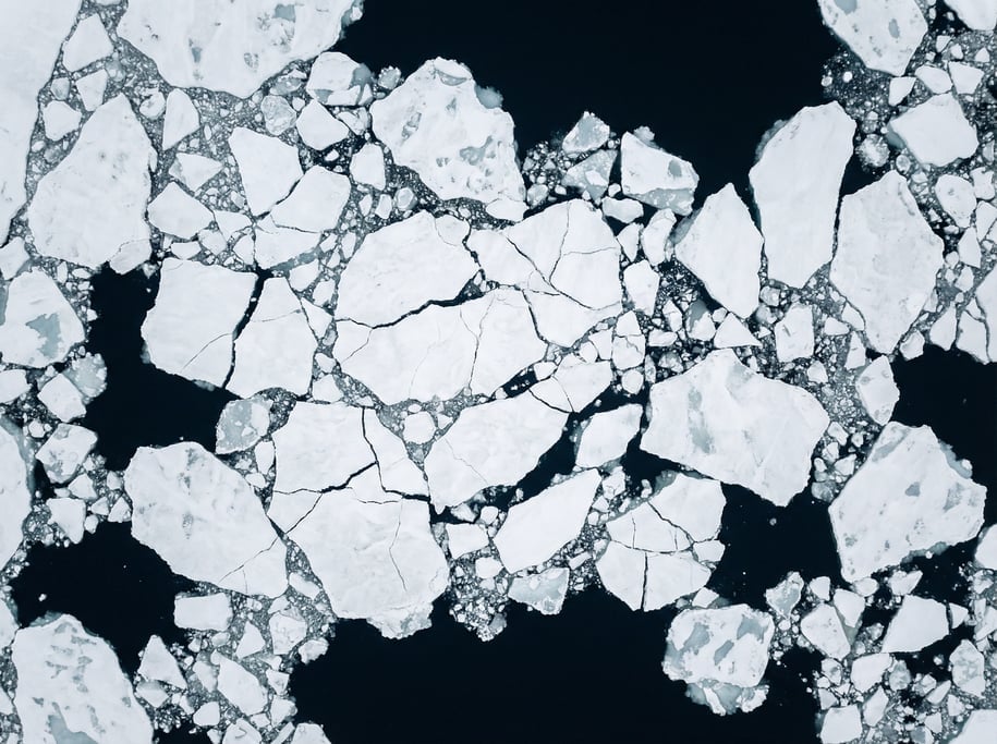 Drone view of ice floes on a dark arctic sea