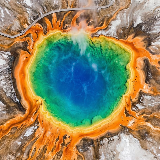 Overhead shot of a hot spring in vivid mineral colors: deep blue center ring