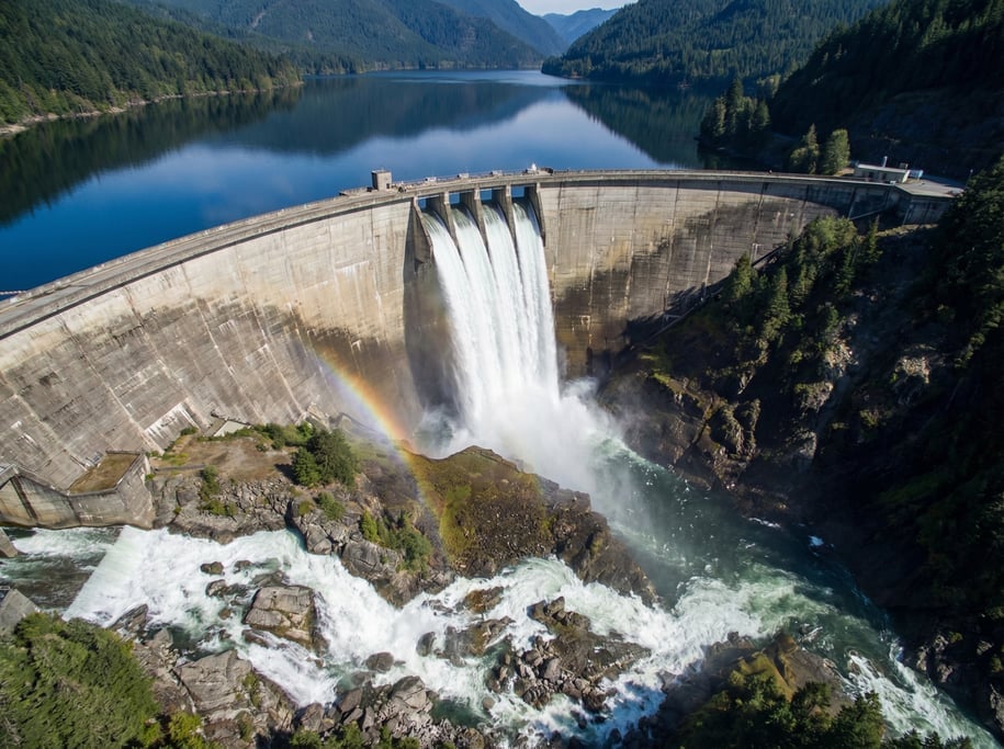 Aerial shot of a dam spillway with white water cascading in a controlled arc