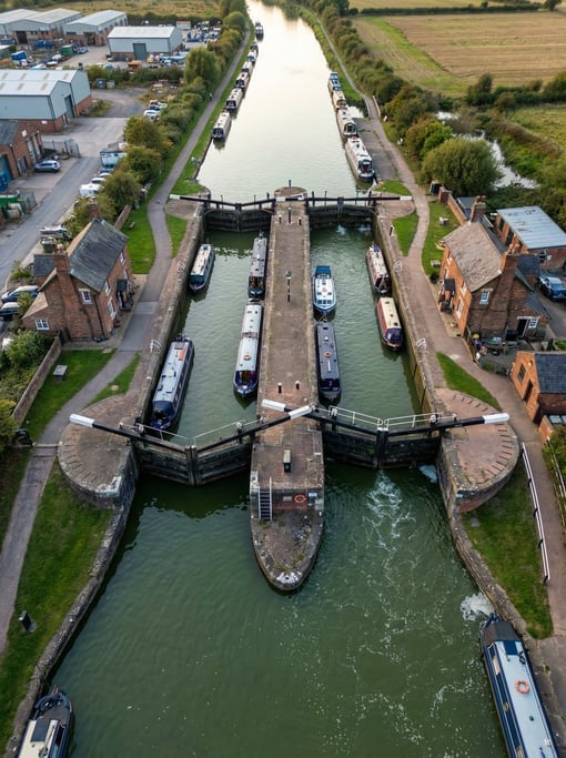 Drone view of a canal lock system from above with boats in different chambers
