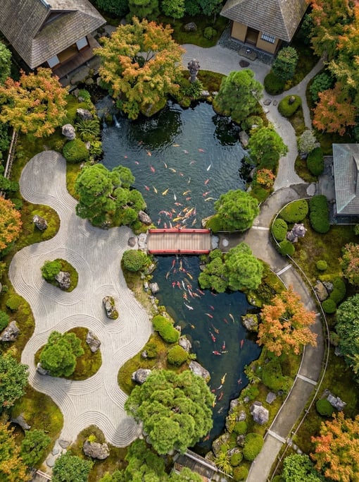 Top-down drone view of a Japanese garden from above with a koi pond, raked gravel patterns