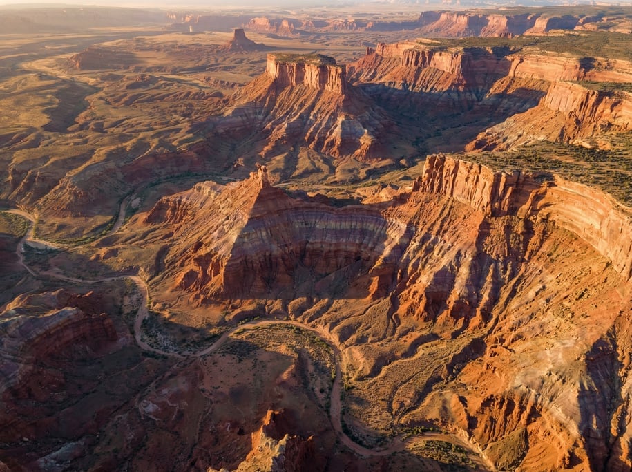Drone view of a desert plateau with erosion-carved mesas and buttes