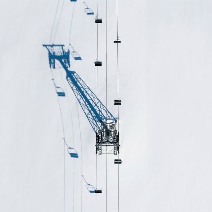 Top-down shot of a ski lift tower and cable from directly above