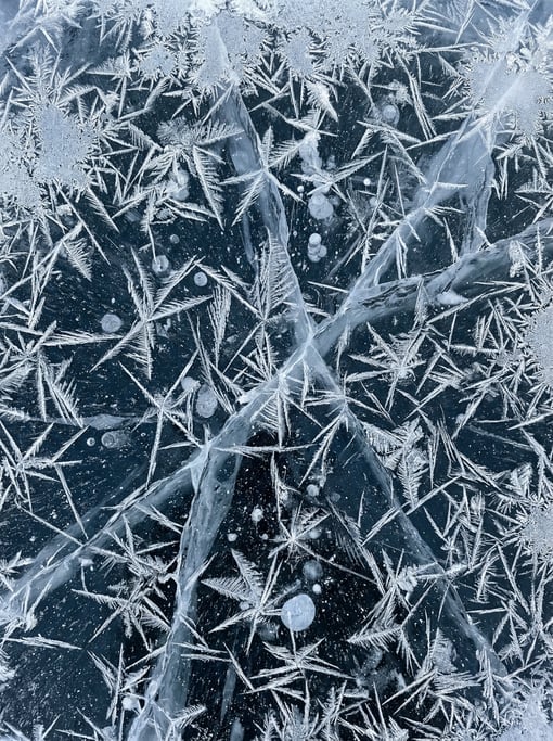 Overhead shot of ice crystals forming on the surface of a frozen lake