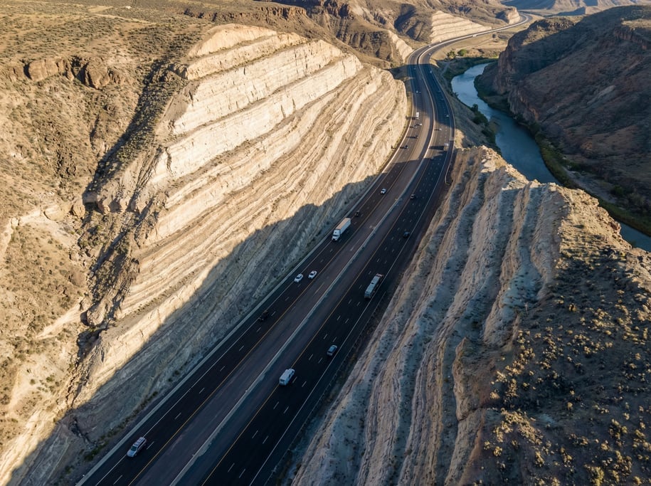 Aerial shot of a modern highway running through a deep rock cutting