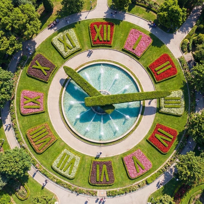Overhead view of a large outdoor clock face built into a public garden