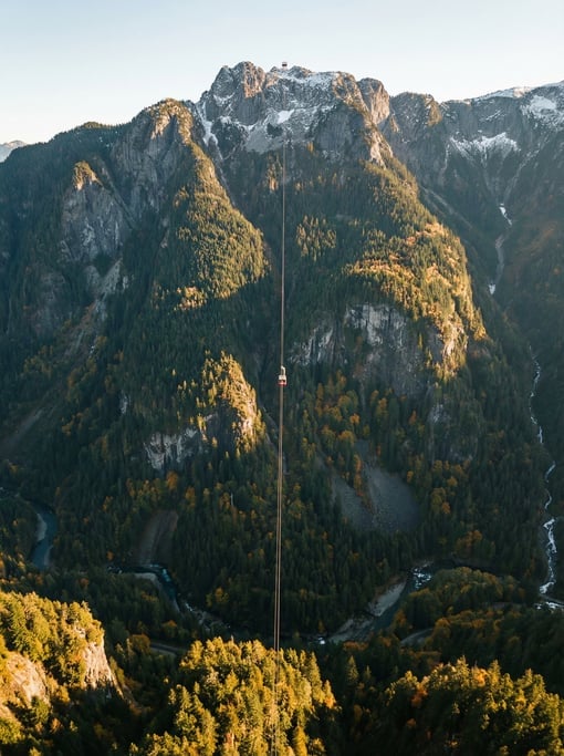 Top-down aerial of a cable car ascending a mountain