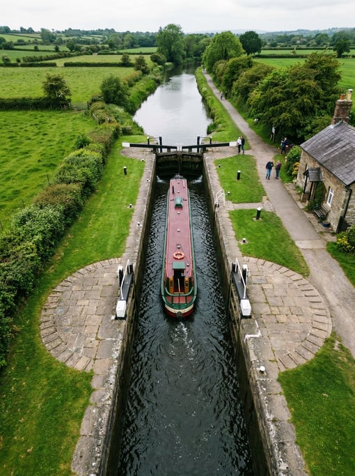 Aerial view of a narrow canal boat passing through a lock