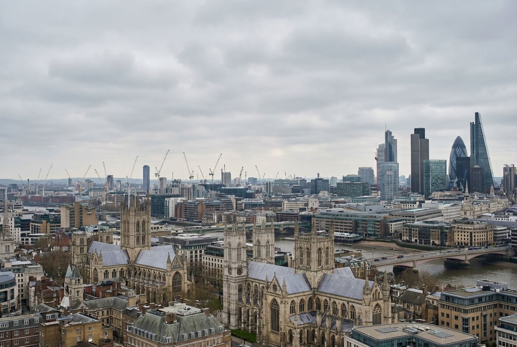 Sweeping panoramic view of a mixed historic and contemporary city skyline at overcast midday