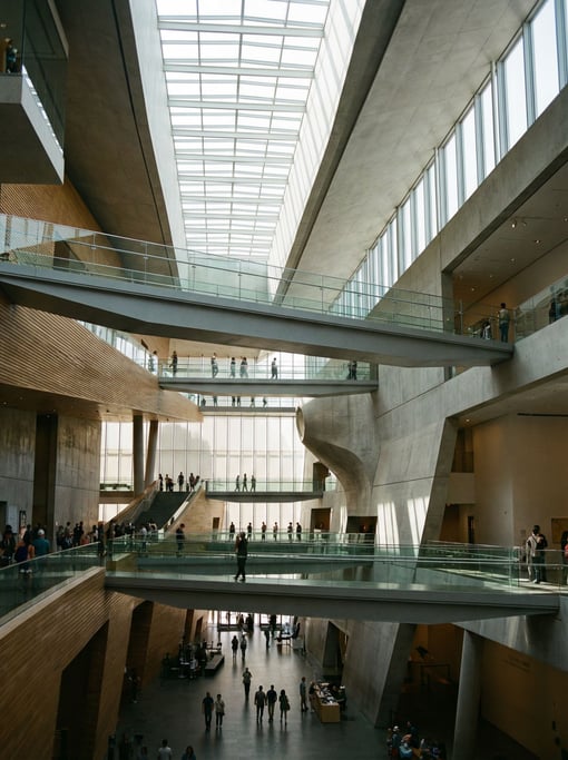 Soaring atrium with floating walkways inside a modern art museum