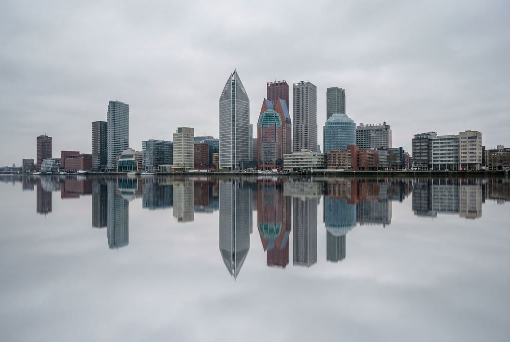 Postmodern city skyline reflected in a calm river at overcast midday