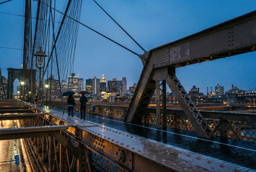 Modern cable-stayed pedestrian bridge at dusk, riveted steel beams and industrial character