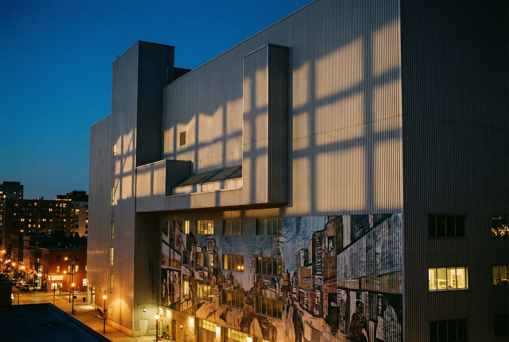 Corrugated metal industrial facade with deep geometric shadow patterns from raking light, dusk