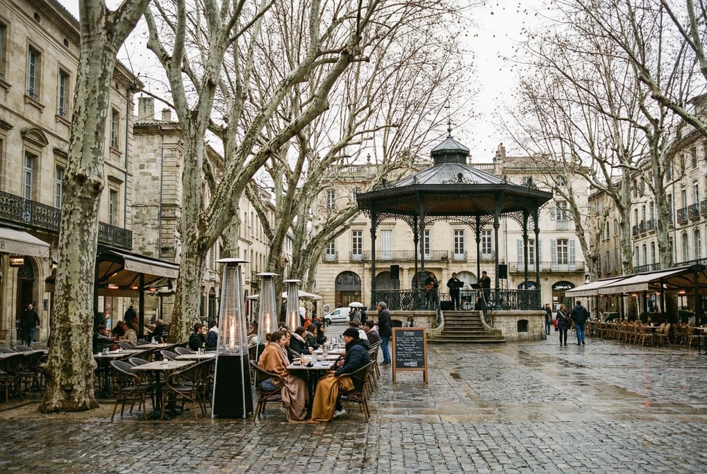Tree-shaded plaza with a bandstand in a European city, outdoor restaurant tables under plane trees