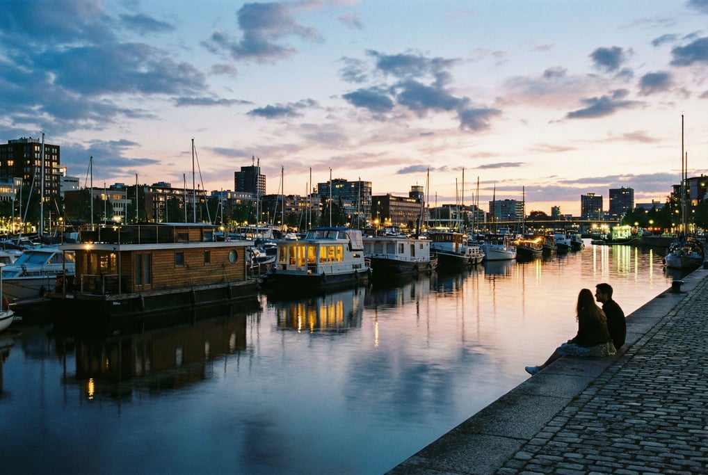 City marina lined with houseboats moored along the quay, dusk, reflections in the water