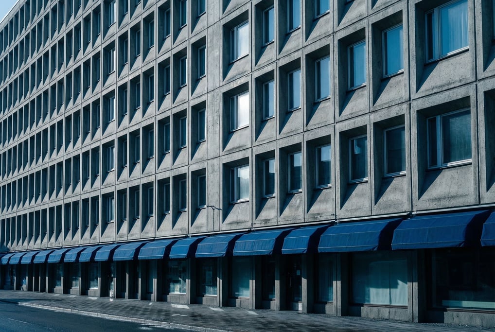 Brutalist concrete building facade with repetitive windows creating a rhythmic grid pattern