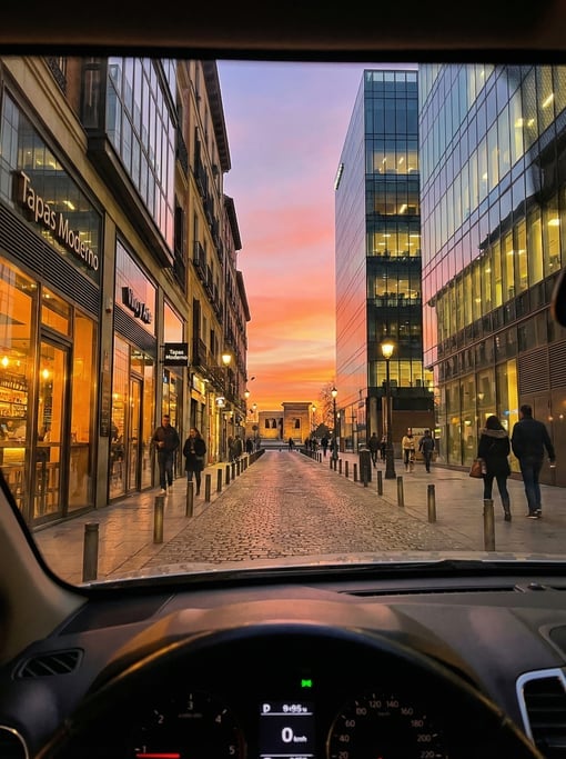First-person perspective driving through a narrow Malasaña side street with contemporary tapas bars