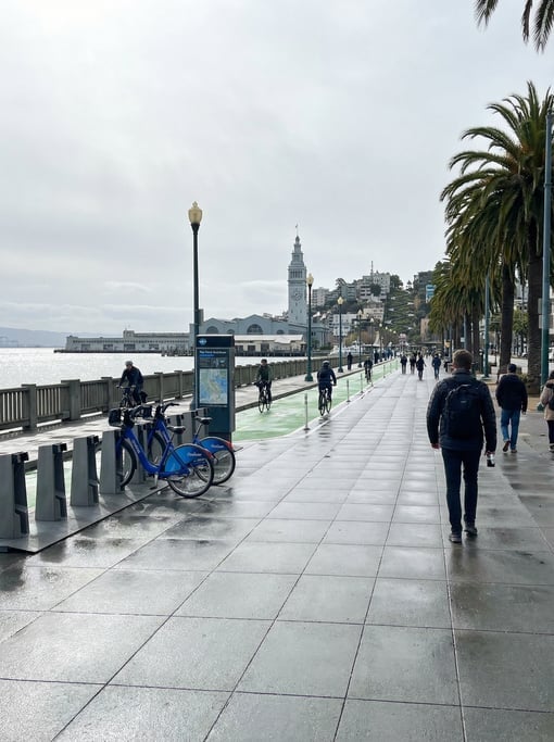 Point-of-view shot walking through the Embarcadero waterfront promenade in San Francisco on a bright
