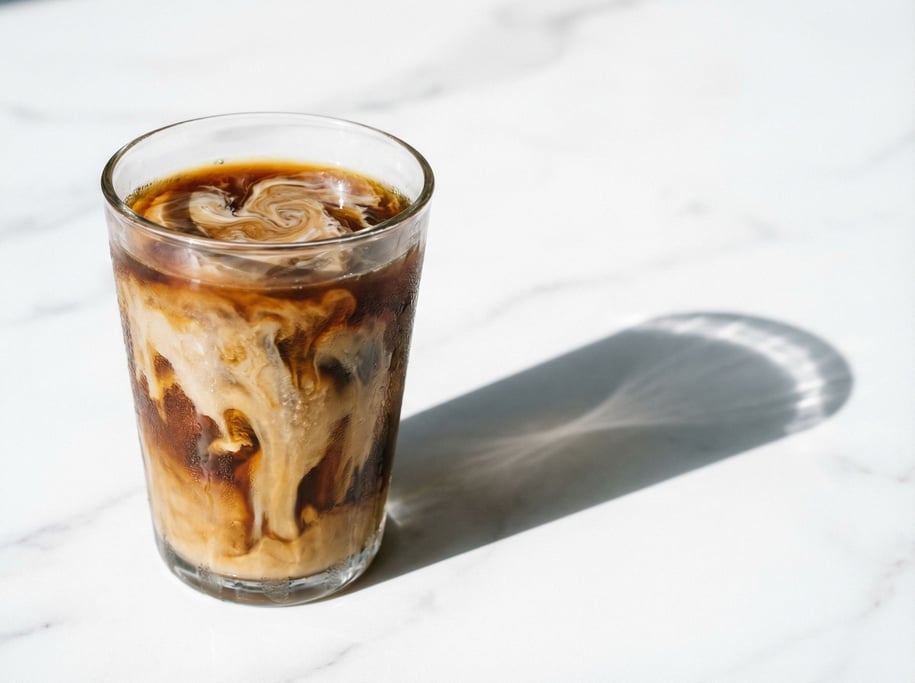 A single glass of cold brew coffee with oat milk creating a marbled swirl pattern
