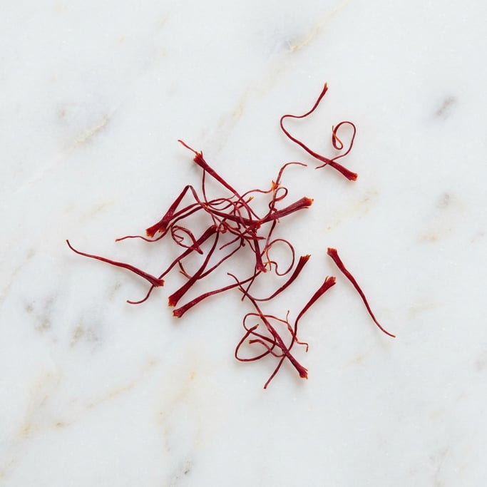 Saffron threads scattered across a white marble surface