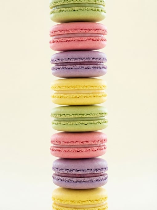 Vertical shot of macarons stacked in a tall tower, alternating colors of pistachio green