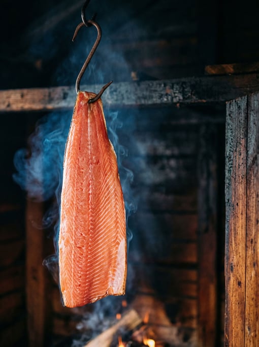 Vertical composition of a smoked salmon filet hanging from a hook