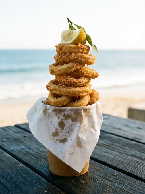 Vertical frame of calamari rings stacked in a tall paper cone lined with parchment