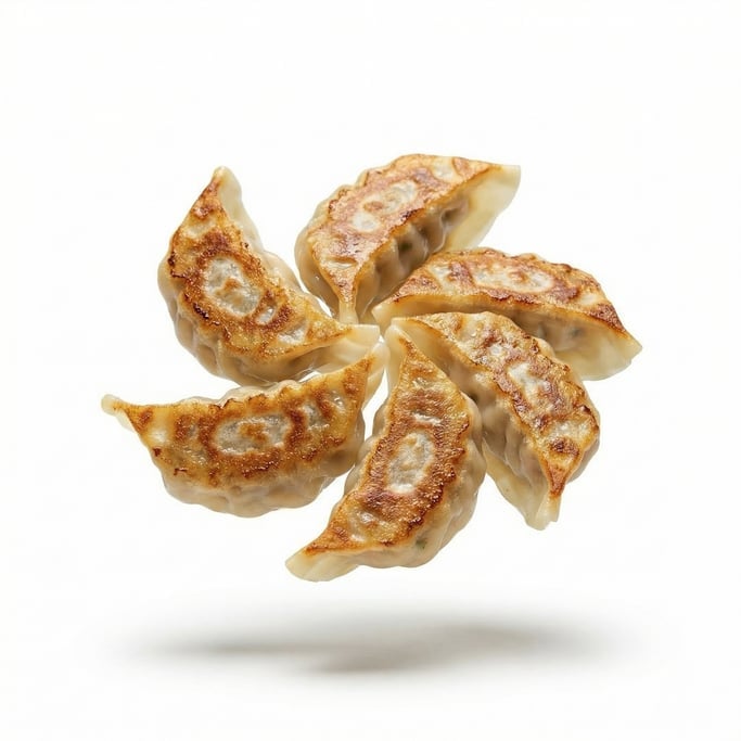 A stack of fresh gyoza dumplings with crispy bottoms, floating in mid-air