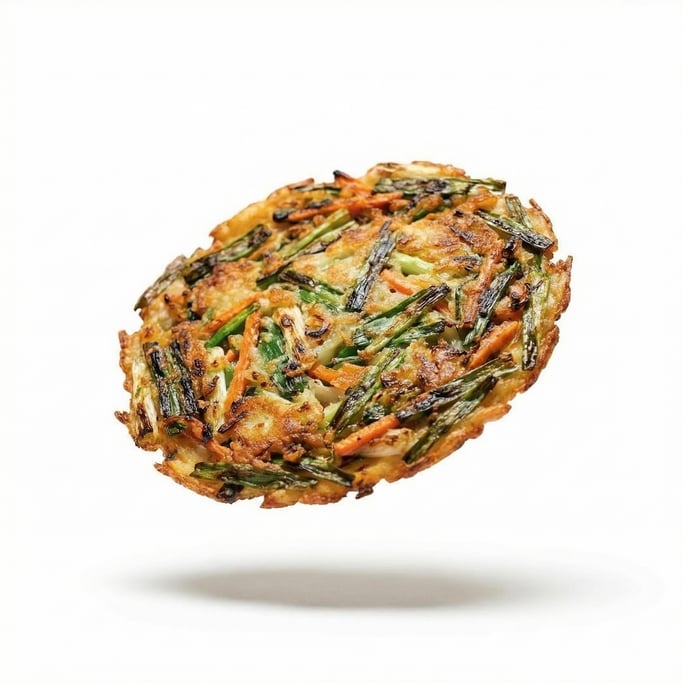 Crispy Korean pancake (pajeon) with green onions, floating in mid-air at a slight angle